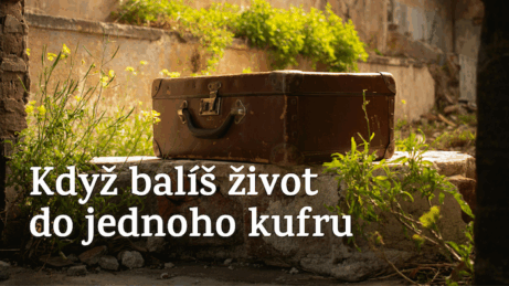 Starý kufr mezi kameny a květinami – symbol minulosti, vzpomínek a rozhodnutí, co si neseme dál.