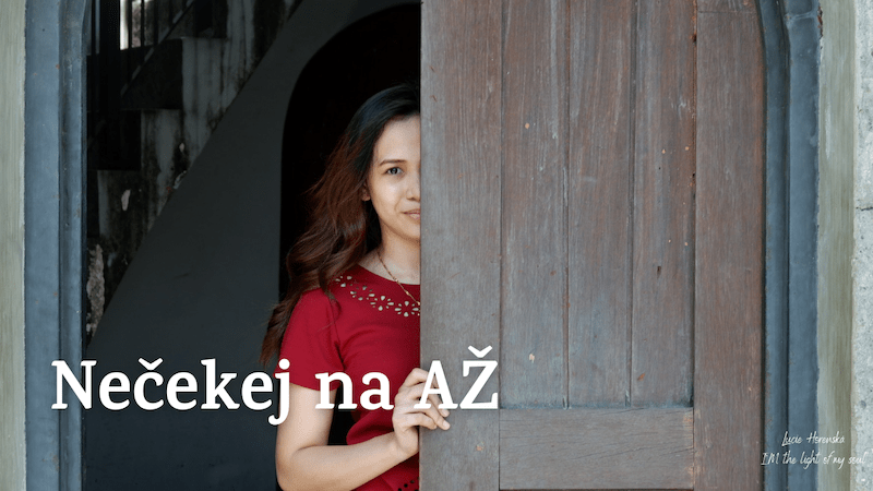 Žena v červených šatech vychází ze starých dřevěných dveří, polovina její tváře je ještě skrytá – symbolizuje odvahu opustit stagnaci a vykročit do nového začátku.